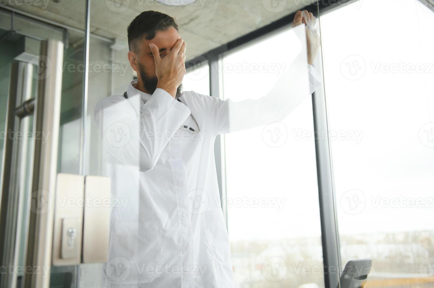 Portrait of exhausted tired young arab male doctor after hard day at work photo