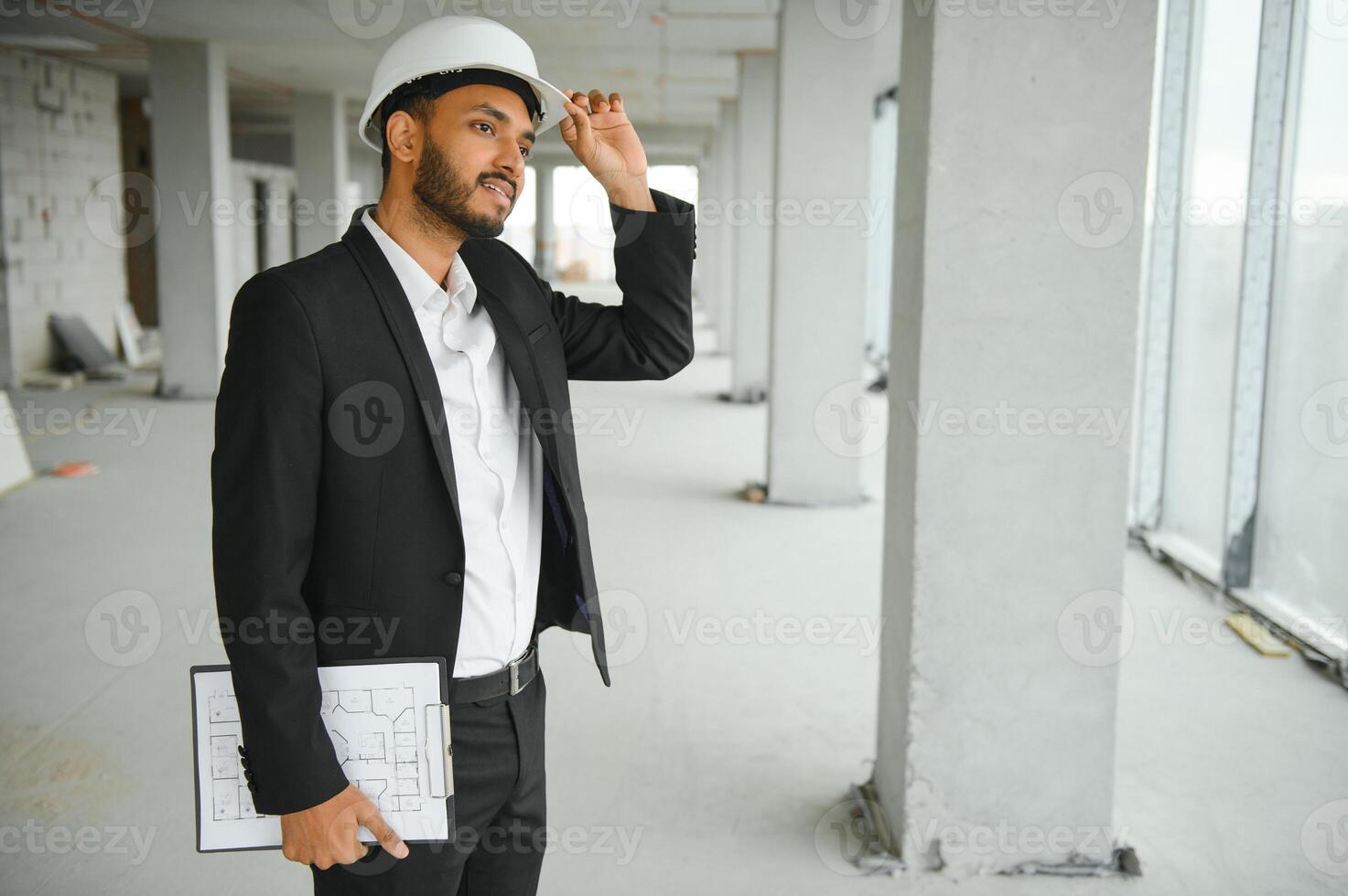 Asian engineer handsome man or architect with white safety helmet in construction site. Standing at modern building construction. Worker asian man working project building photo