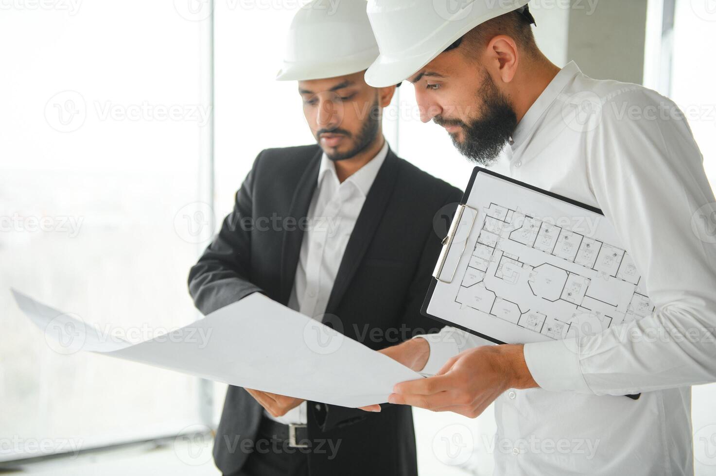 Construction concept of multiracial Engineer and Architect working at Construction Site with blue print photo