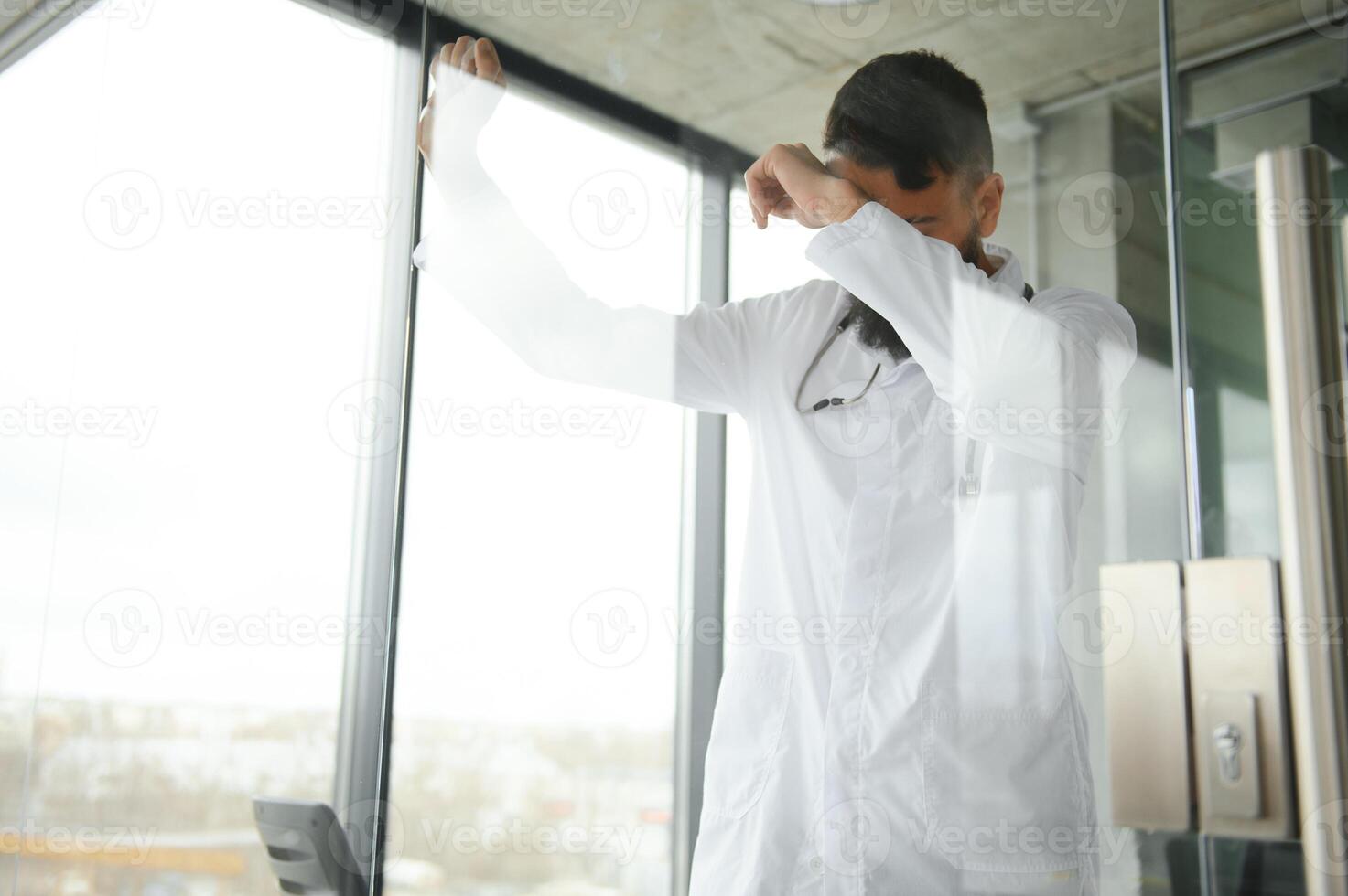 Portrait of pleasant young Arabian doctor in white coat. photo