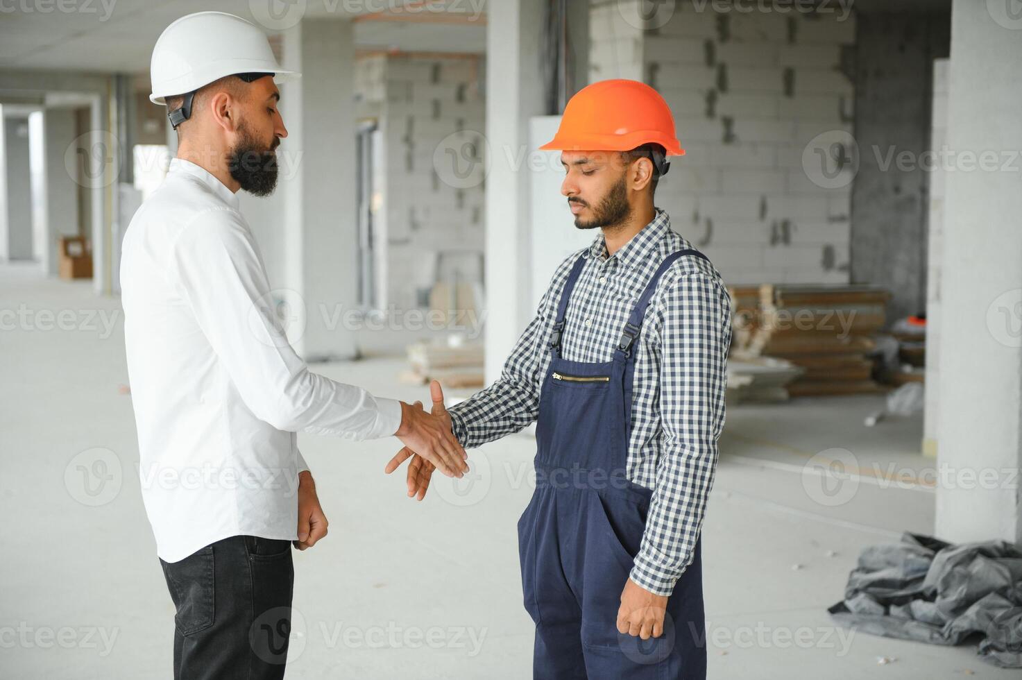 Indian and Arabian engineers. Contractor and architect talking about working on big project. Building in construction process interior. photo