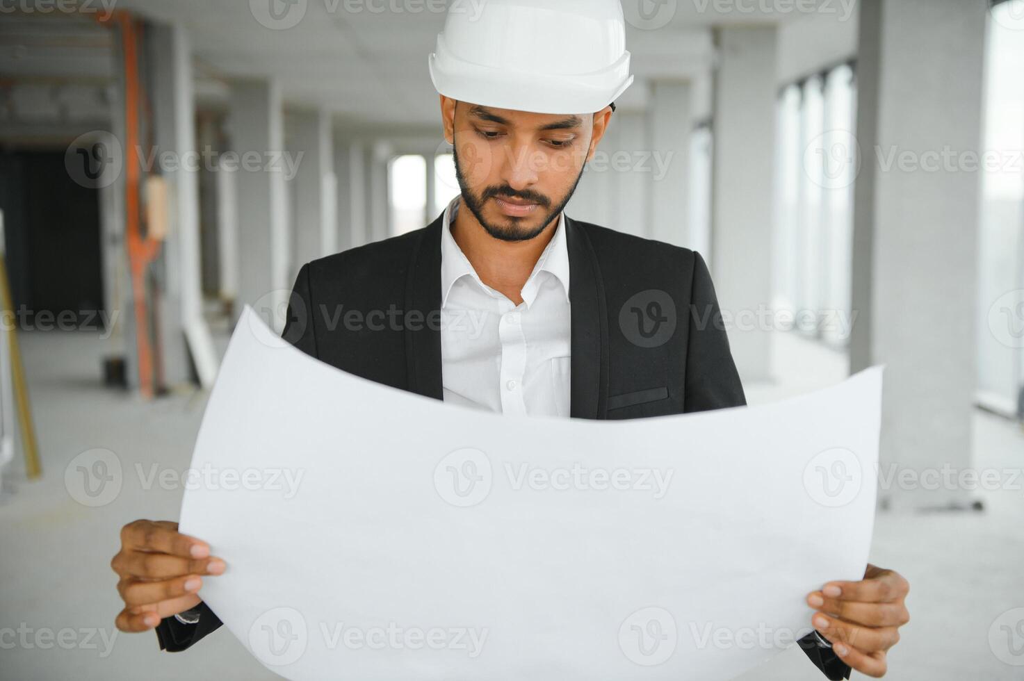 Asian engineer handsome man or architect with white safety helmet in construction site. Standing at modern building construction. Worker asian man working project building photo