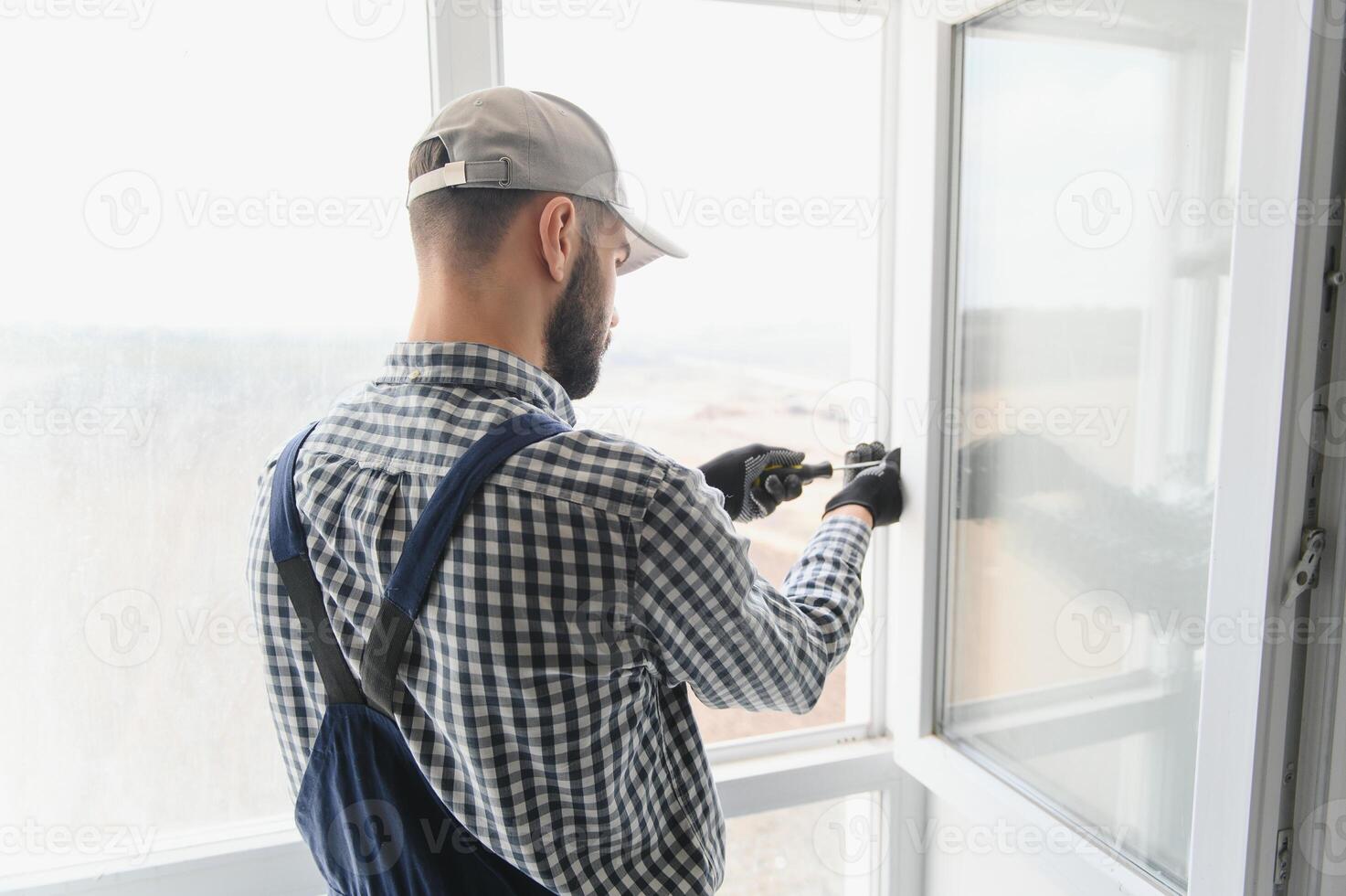 Worker installing plastic window indoors photo