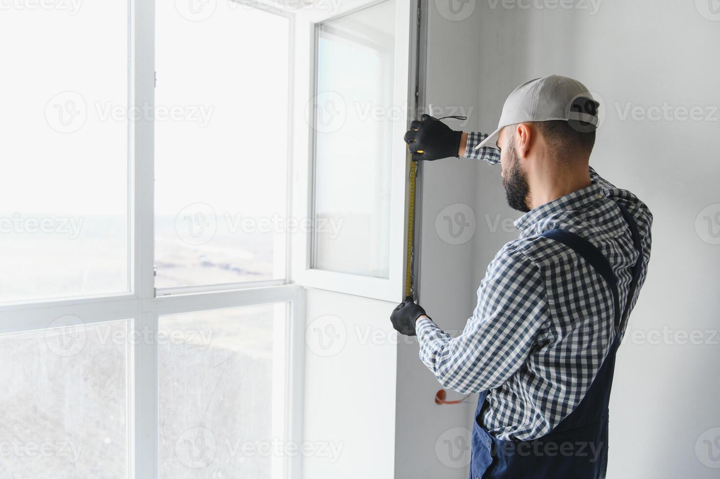 Construction worker installing window in house photo