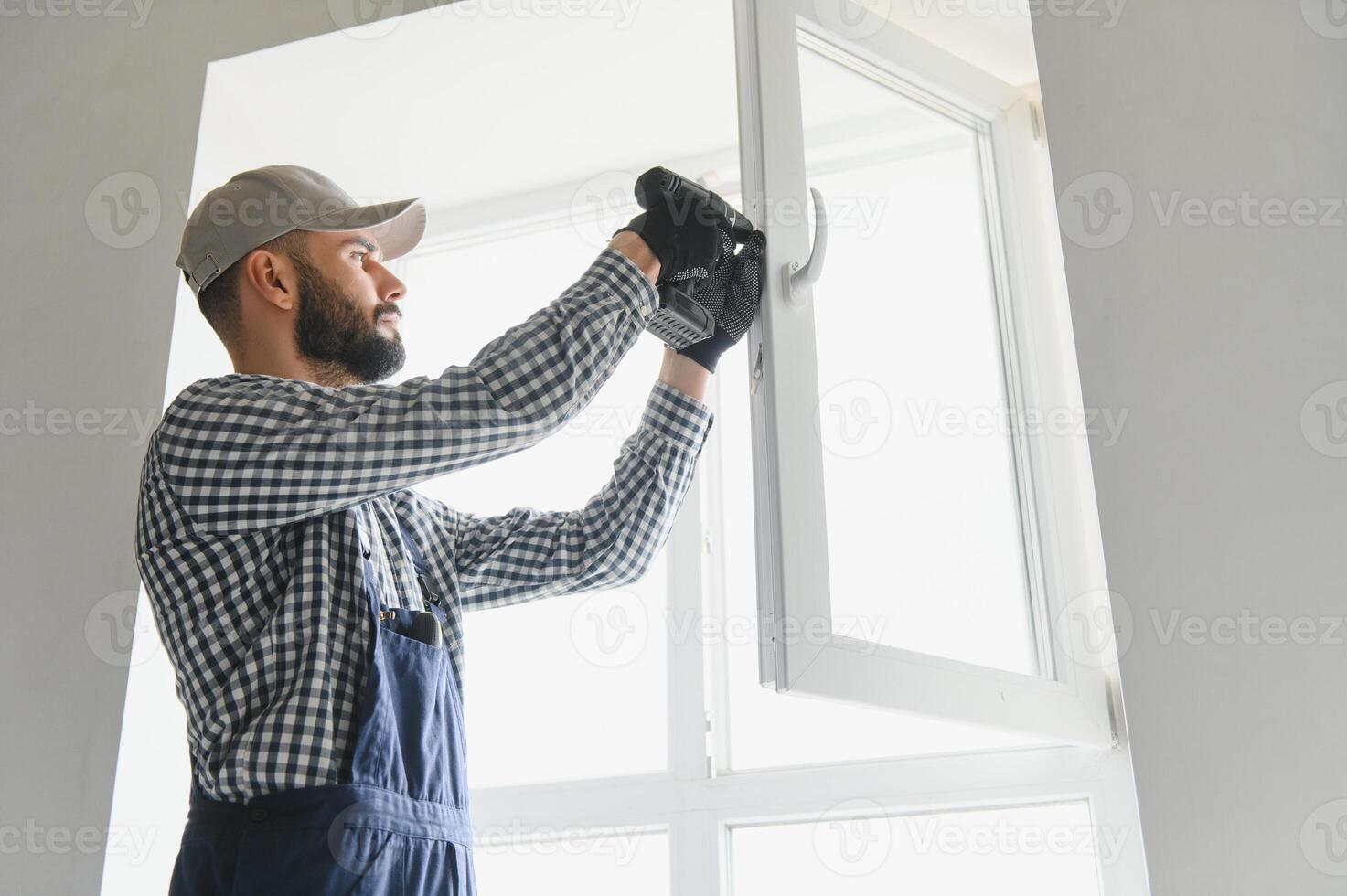 Construction worker installing window in house photo