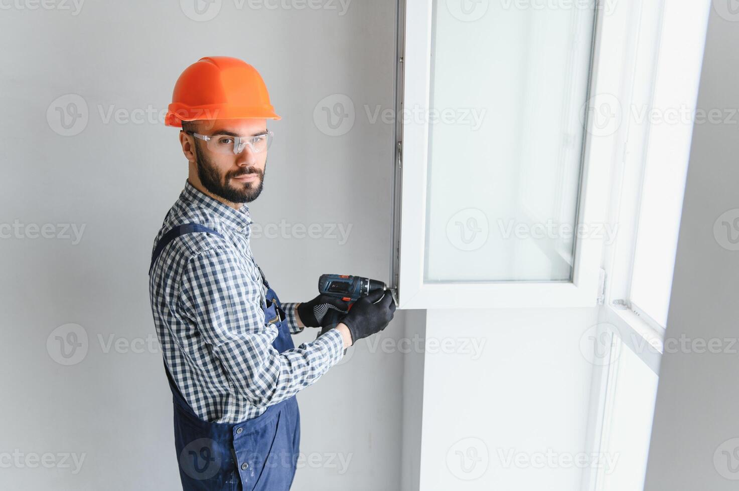 Construction worker installing window in house photo