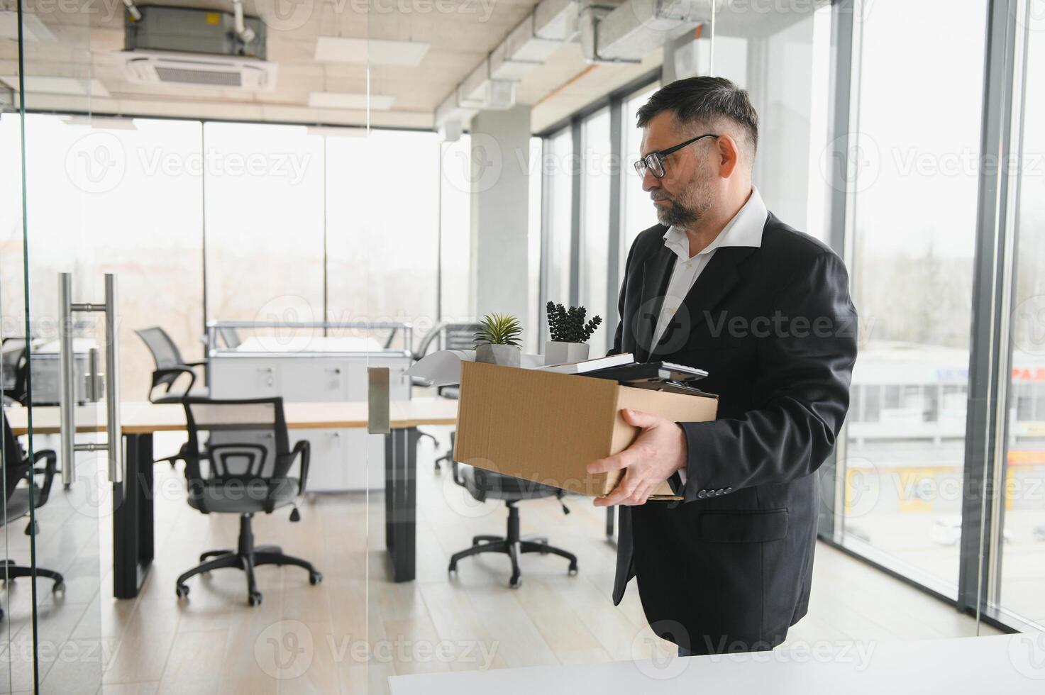 old employee leaving office with the box full of belongings photo