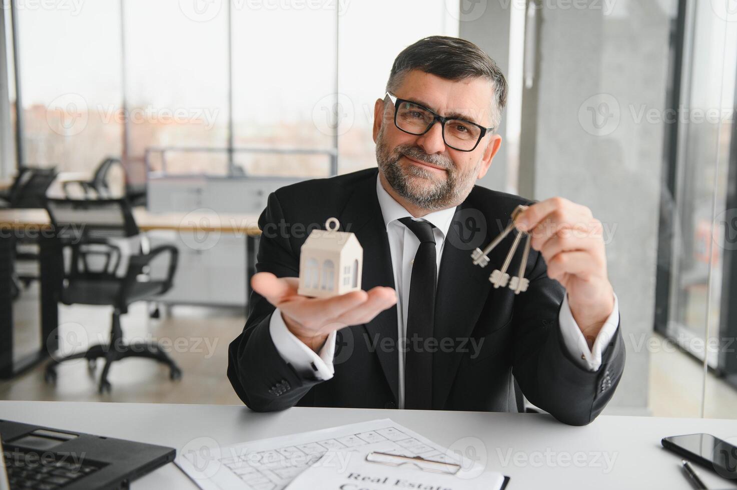 Real estate agent with house model and keys photo