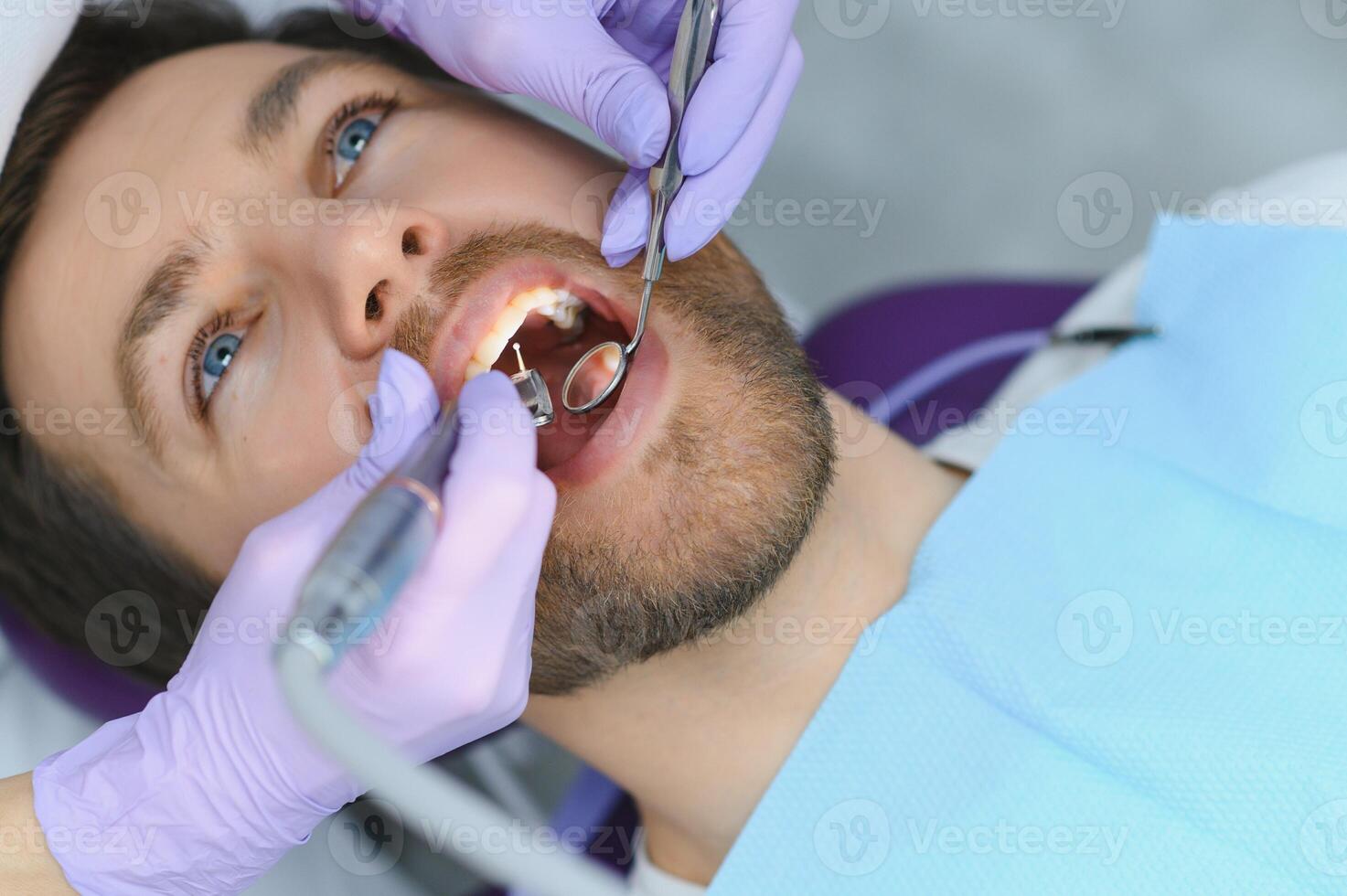 Young man at the dentist. Dental care, taking care of teeth. Picture with copy space for background. photo
