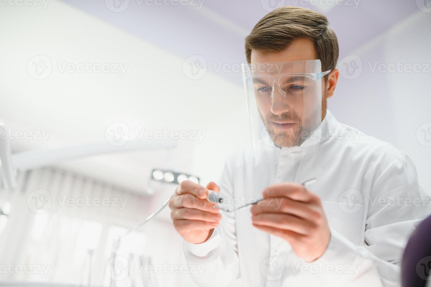 Bottom view. Dentist man with a tool in his hand. photo