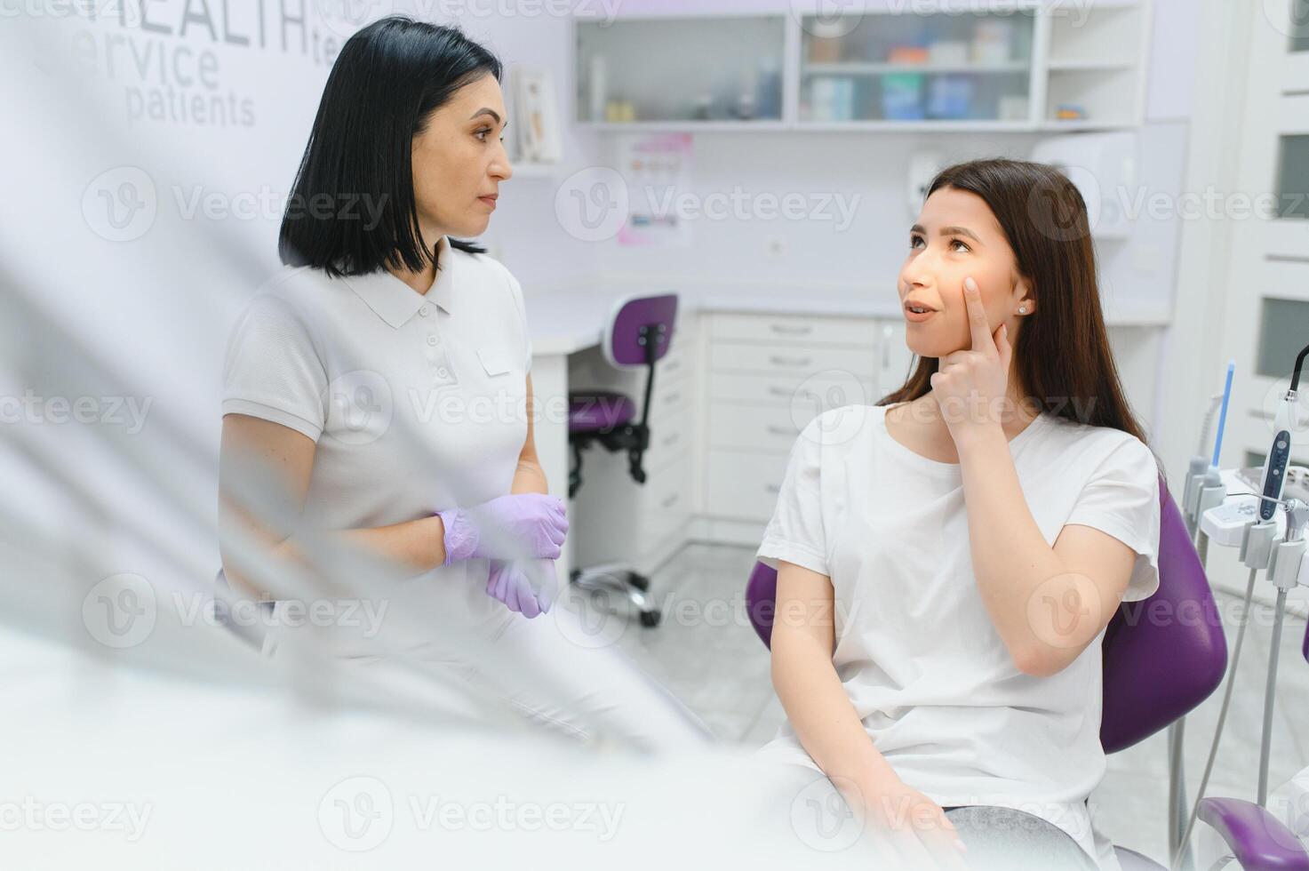 Dentist and patient in dentist office photo
