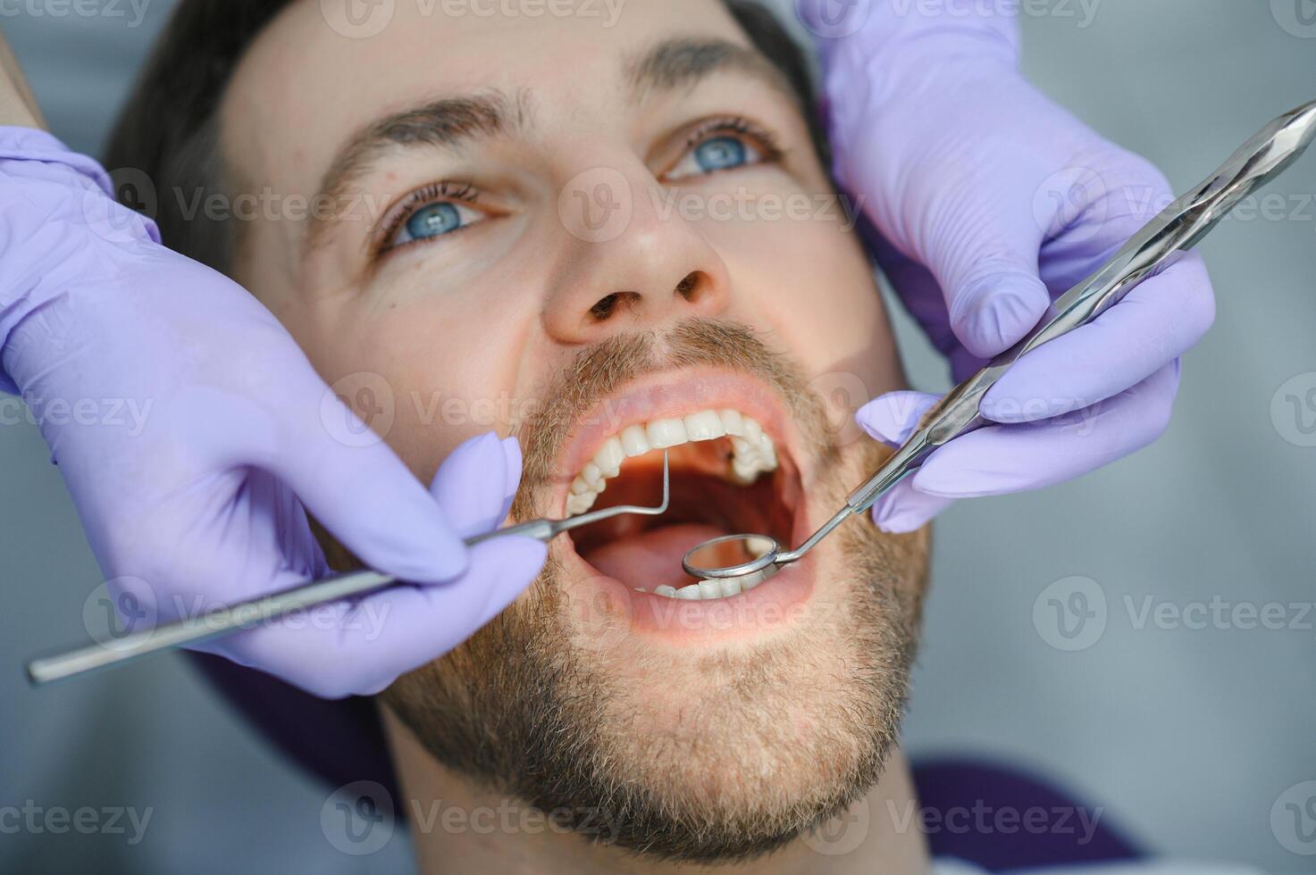Young man at the dentist. Dental care, taking care of teeth. Picture with copy space for background. photo