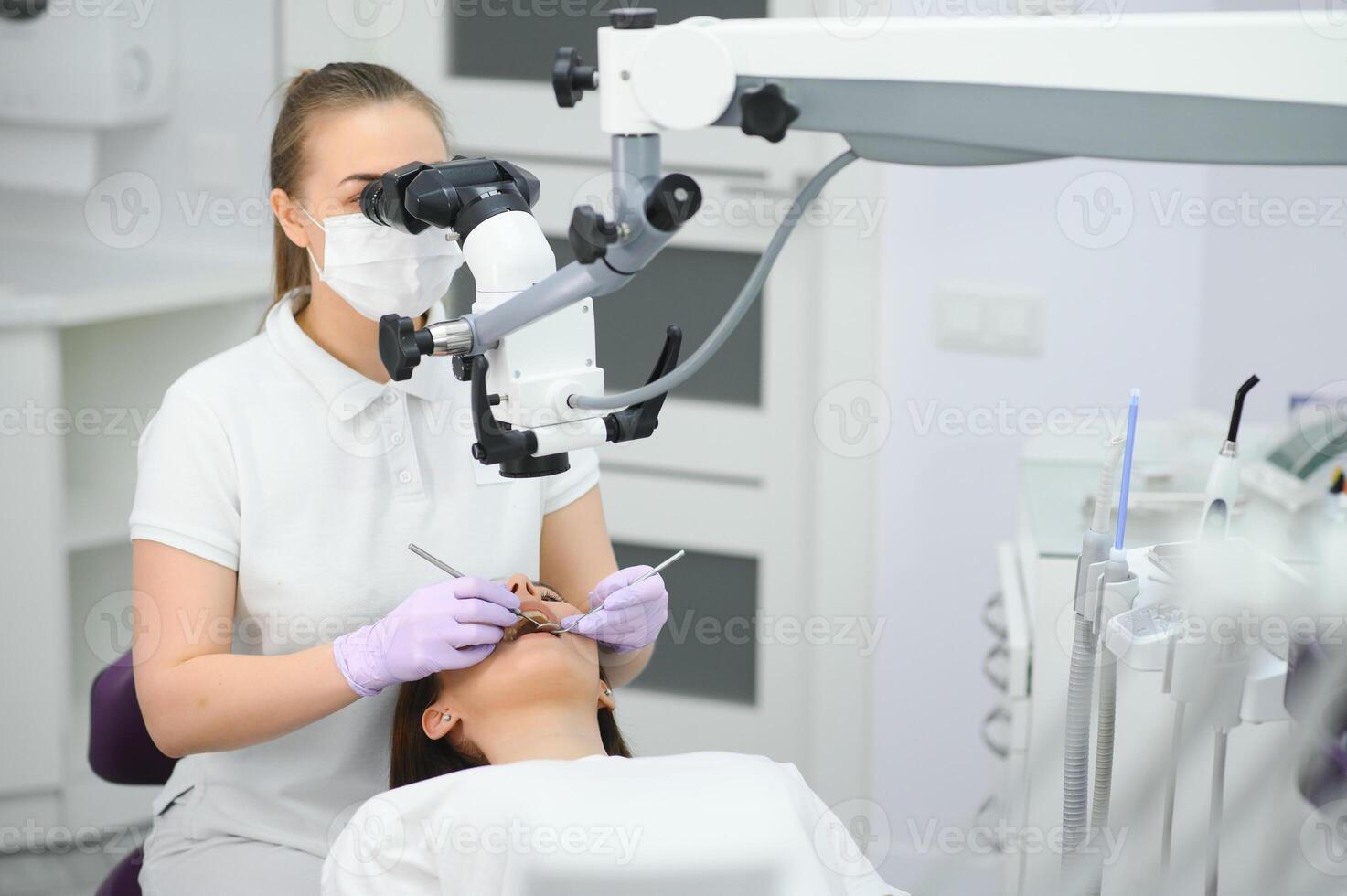 Beautiful young woman having dental treatment at dentist's office. photo