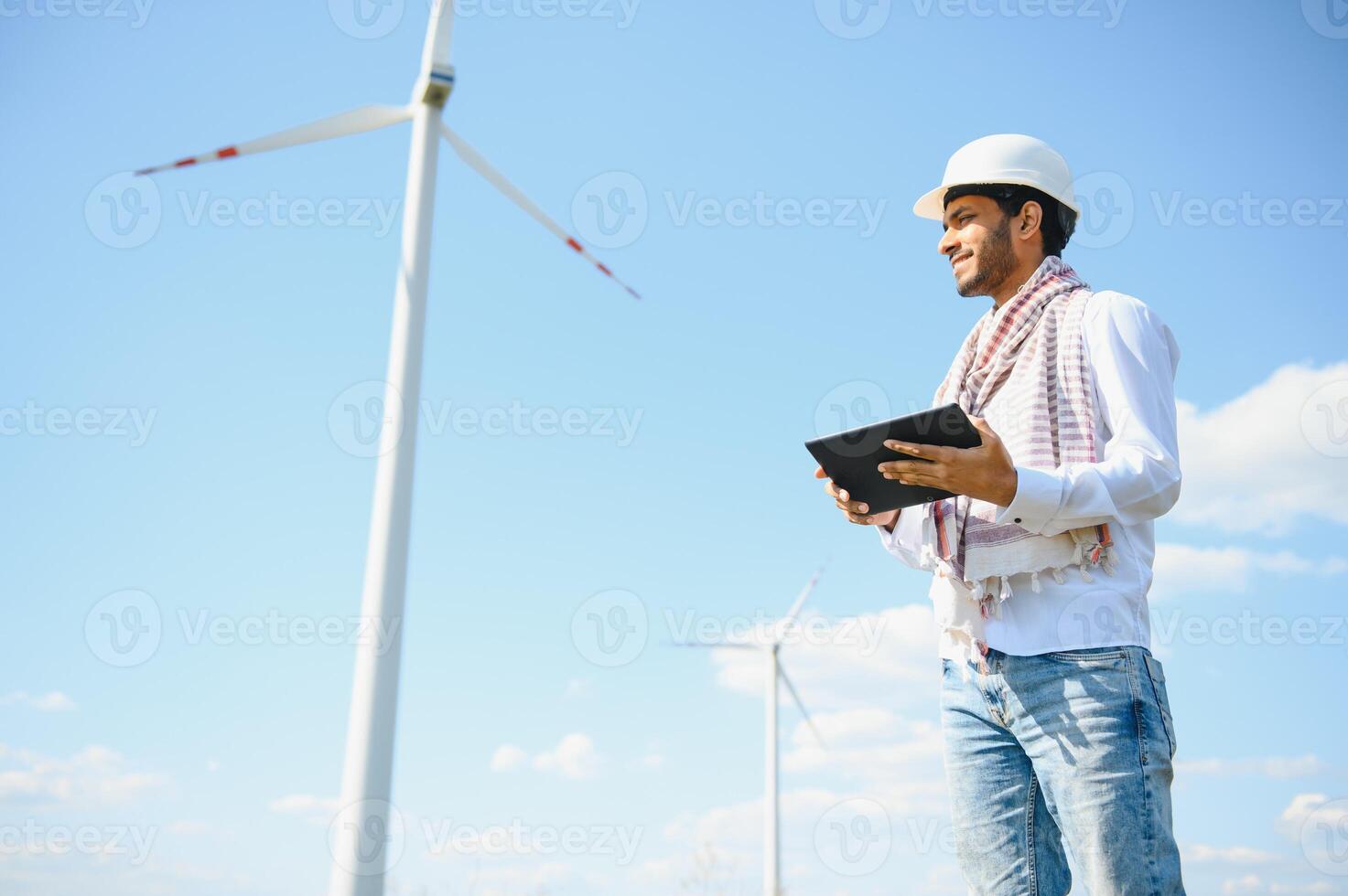 ingeniero India hombre trabajando a molino granja generando electricidad limpiar energía. viento turbina granja generador por alternativa verde energía. asiático ingeniero comprobación controlar eléctrico poder foto