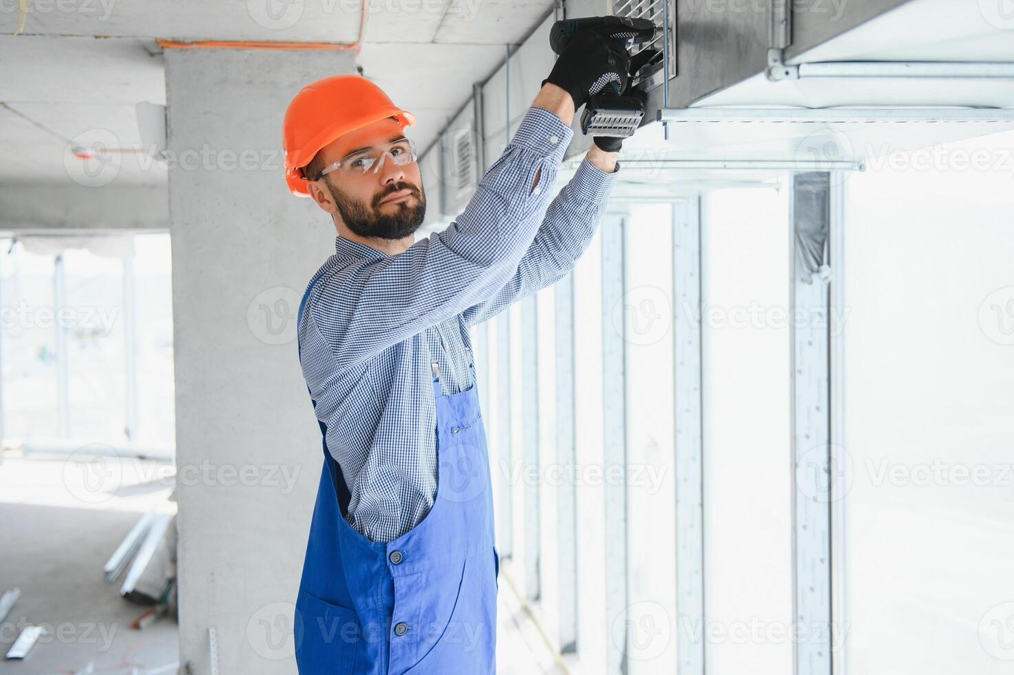 Industrial Theme. Warehouse Heating and Cooling System Installation by Professional Caucasian Technician. Commercial Building Ventilation Rectangle Canals. Air Distribution. photo