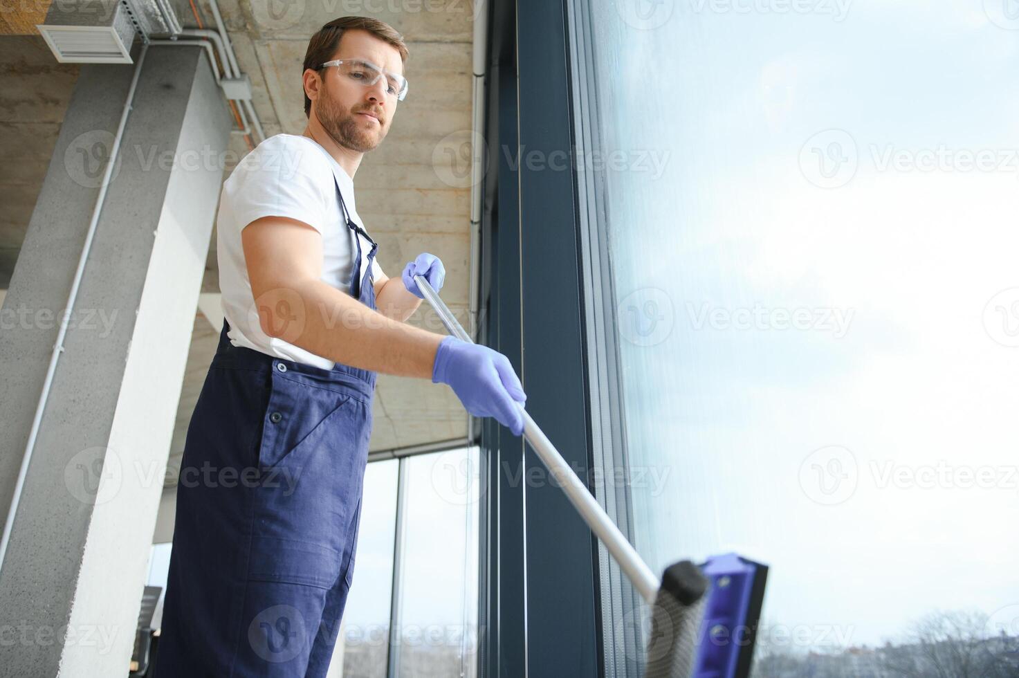 An employee of a professional cleaning service washes the glass of the windows of the building. Showcase cleaning for shops and businesses. photo