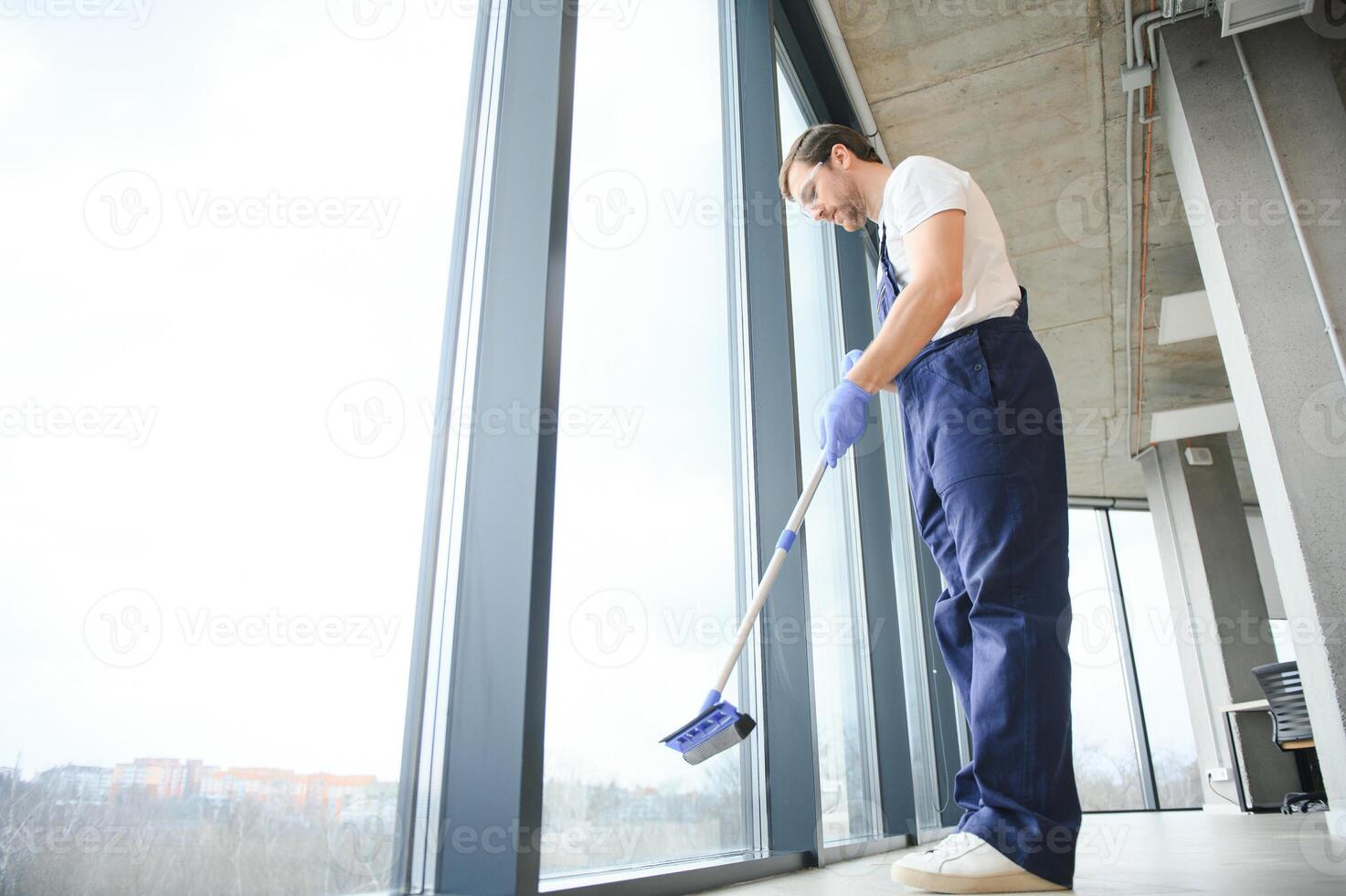 An employee of a professional cleaning service washes the glass of the windows of the building. Showcase cleaning for shops and businesses. photo