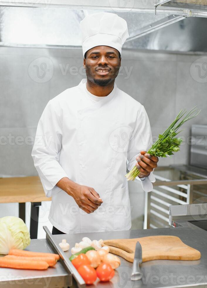 African American chef cooking tasty salad in kitchen photo