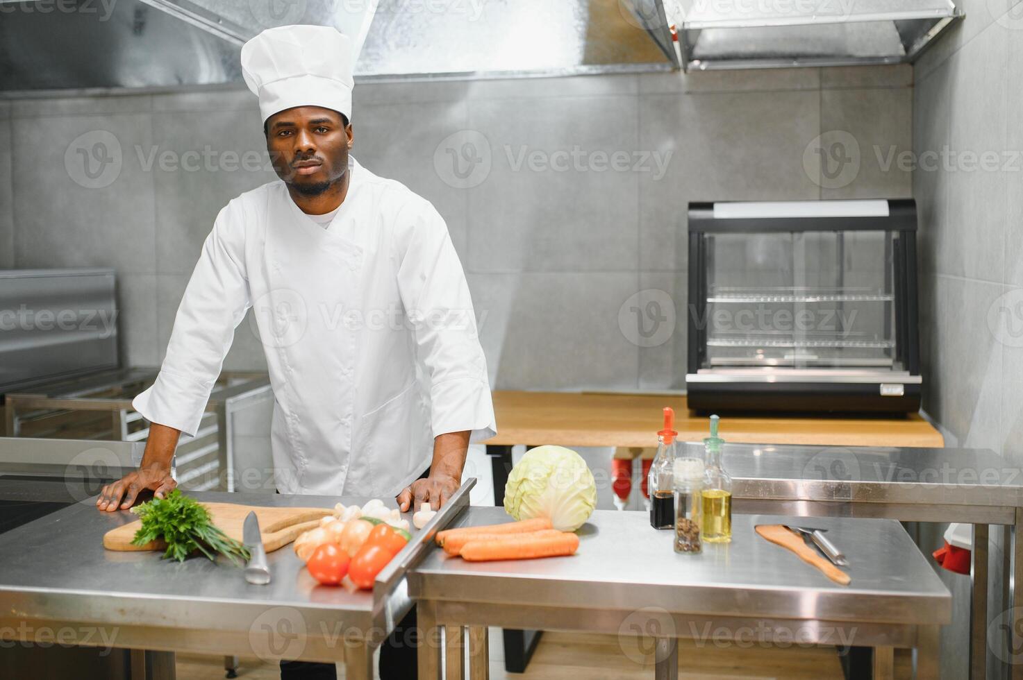 african american chef looking at camera at restaurant kitchen photo