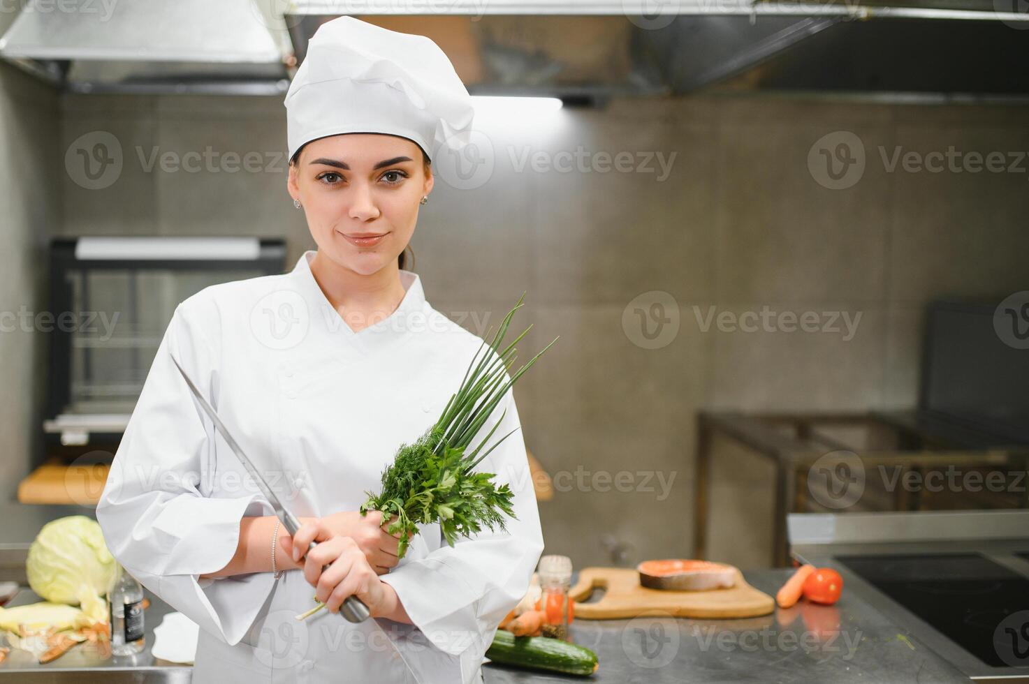 cooking and food concept. smiling female chef, cook or baker chopping vegetables photo