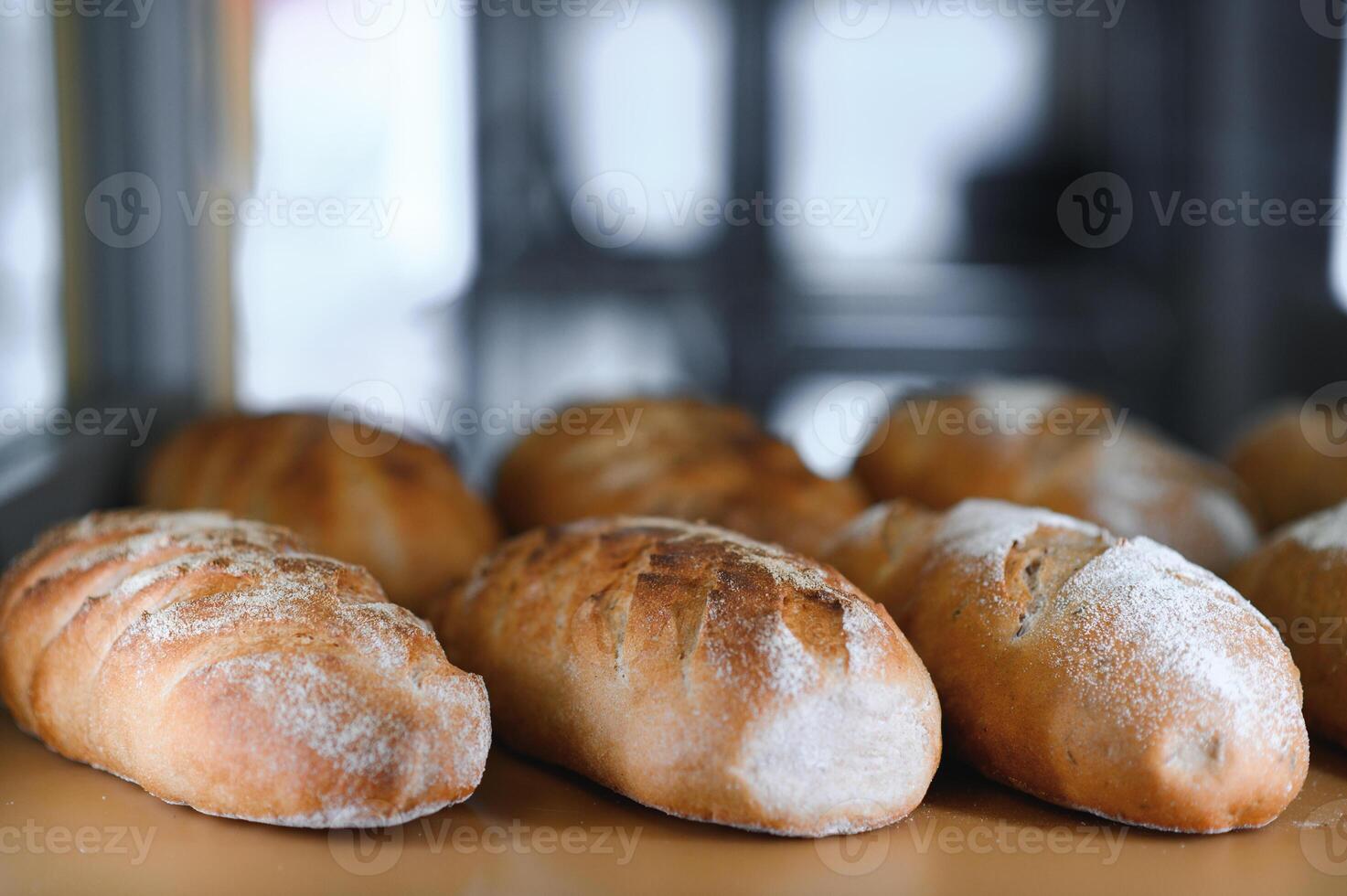 Freshly baked sourdough bread with a golden crust on bakery shelves. Baker shop context with delicious bread photo