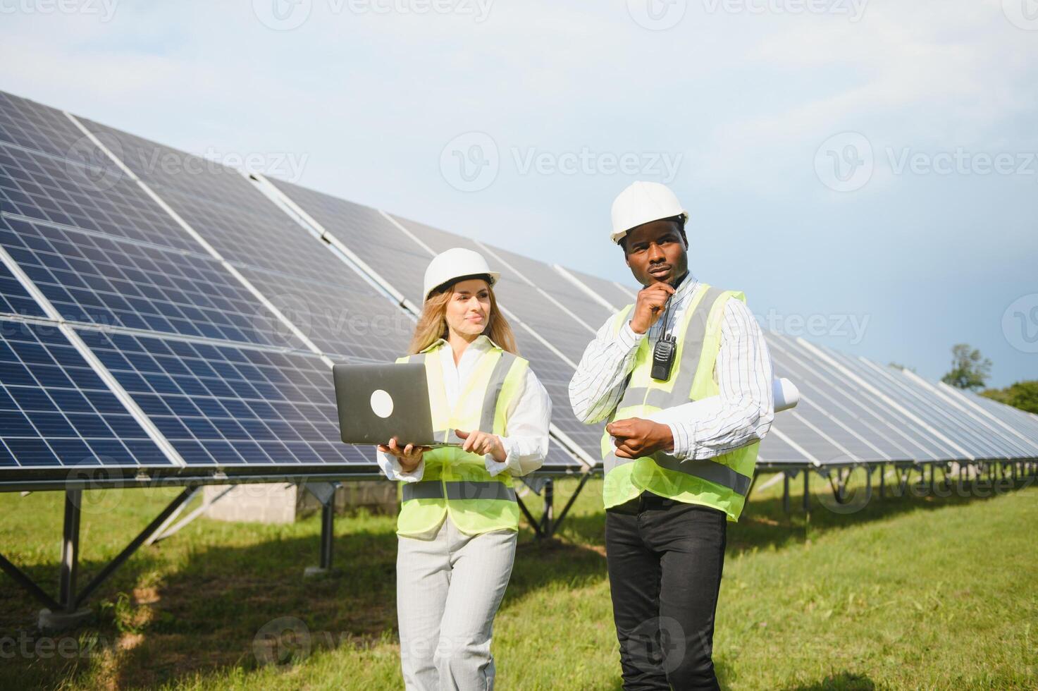 African american businessman and european female engineer talking near solar panels photo