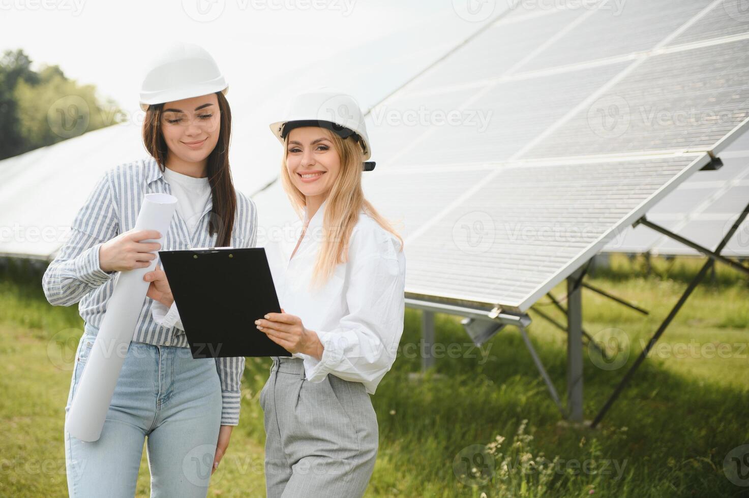 Portrait of female engineers spending time outside near solar panels photo