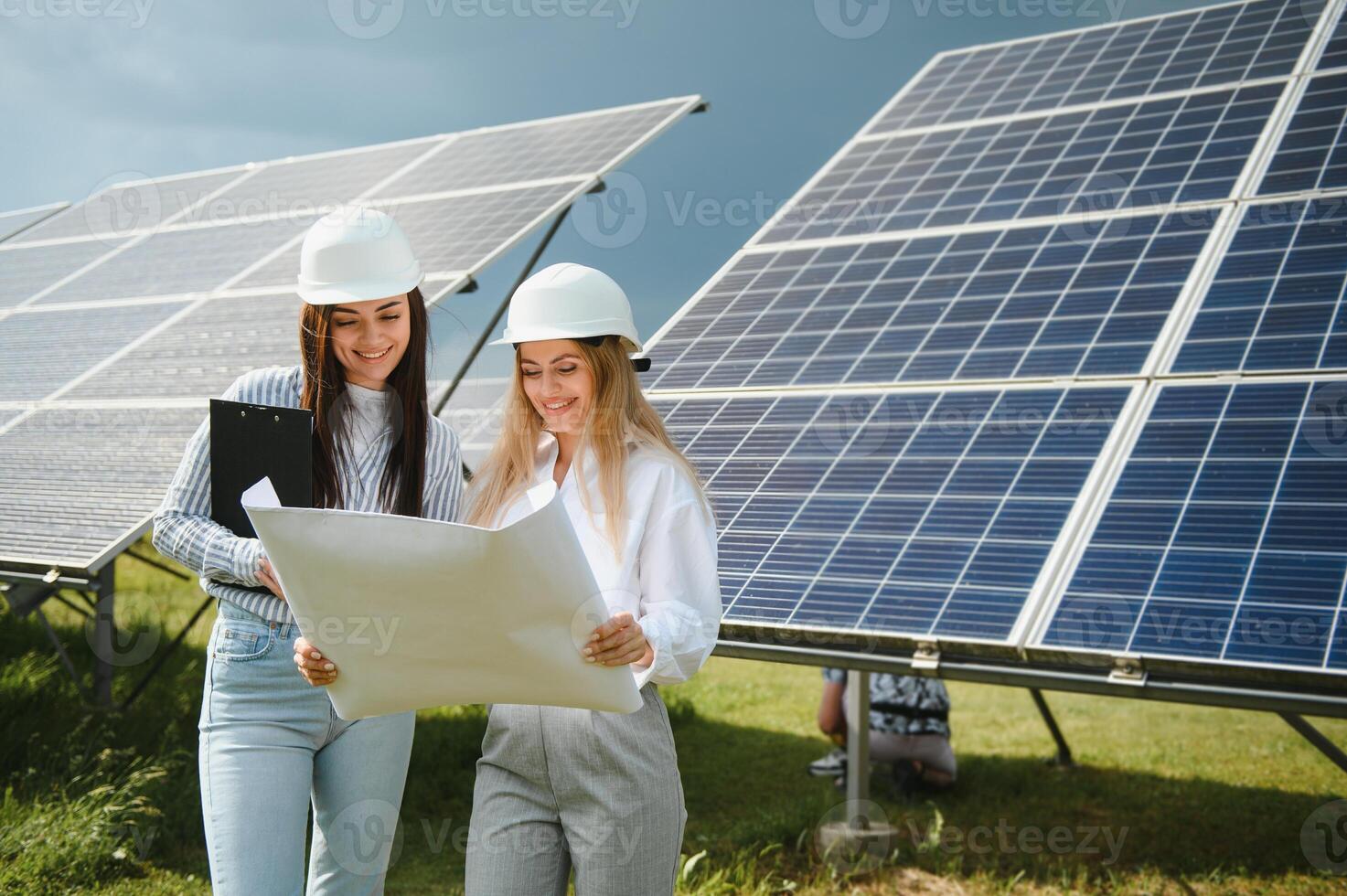 Portrait of female engineers spending time outside near solar panels photo