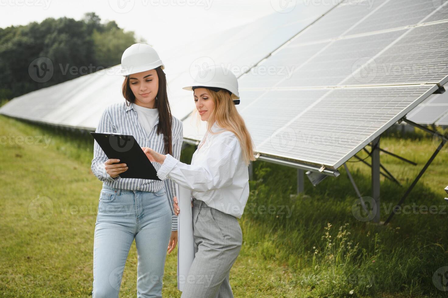 Portrait of female engineers spending time outside near solar panels photo