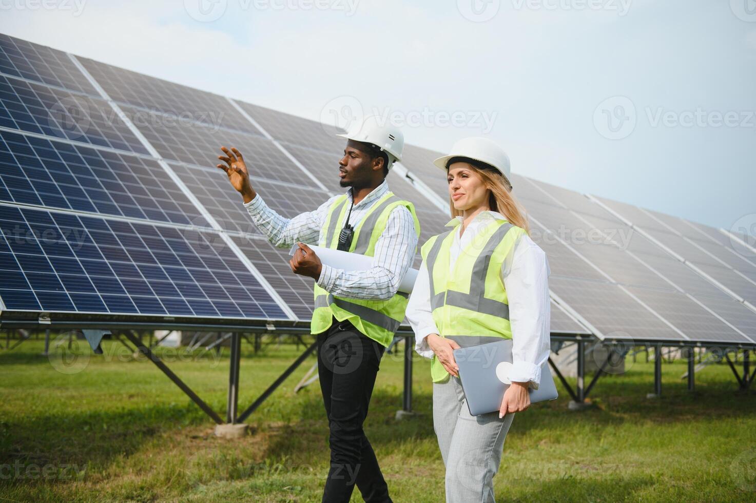 African american businessman and european female engineer talking near solar panels photo