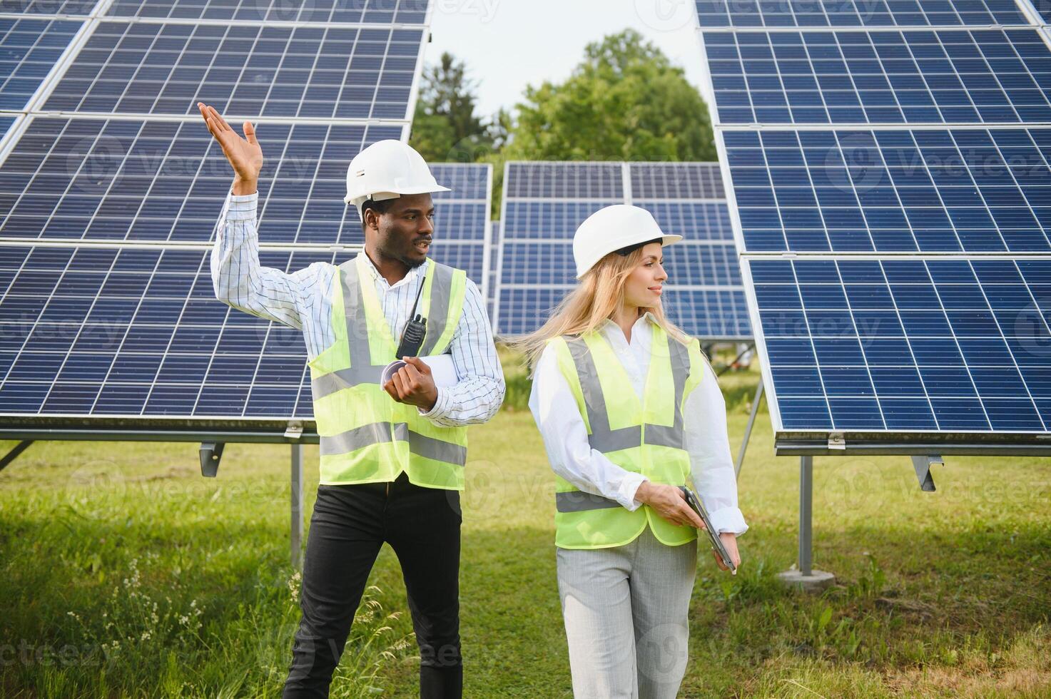 African american businessman and european female engineer talking near solar panels photo