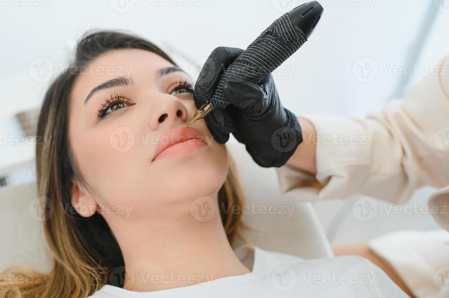 Permanent make up procedure. Lip makeup in tattoo salon. photo