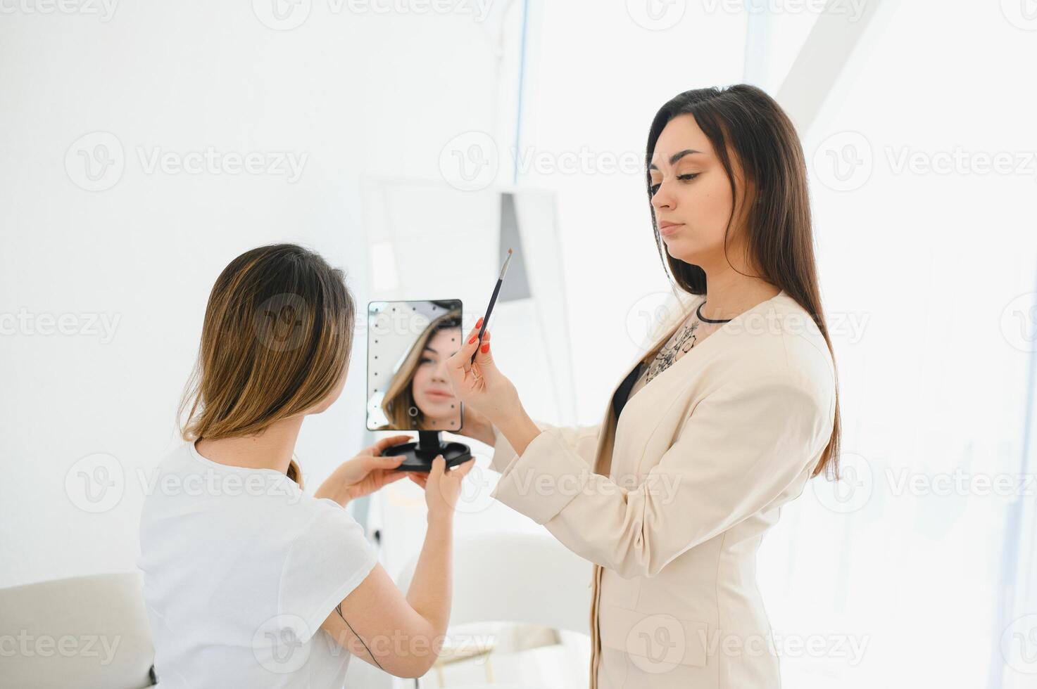 Portrait of a beautiful woman, her lips are painted with pink lipstick, looking in the mirror. photo