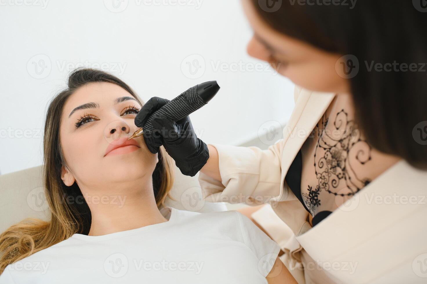 Healthy Spa Young Beautiful Woman Having Permanent Make up on her Lips. Close-up photo