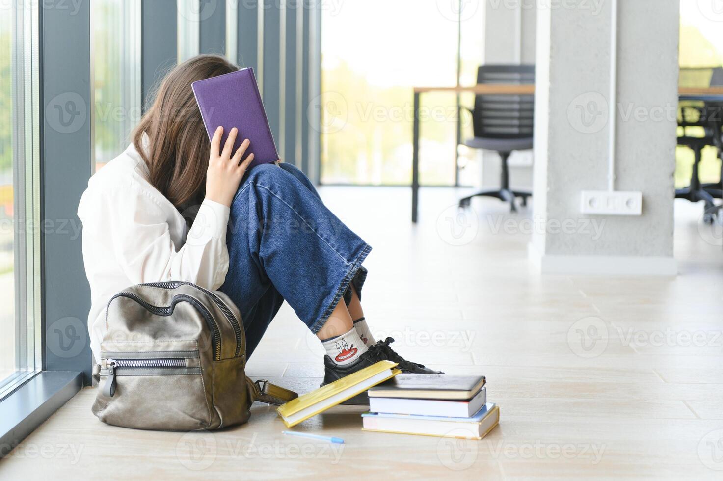 Lonely sad schoolgirl while all her classmates ignored her. Social exclusion problem. Bullying at school concept. photo