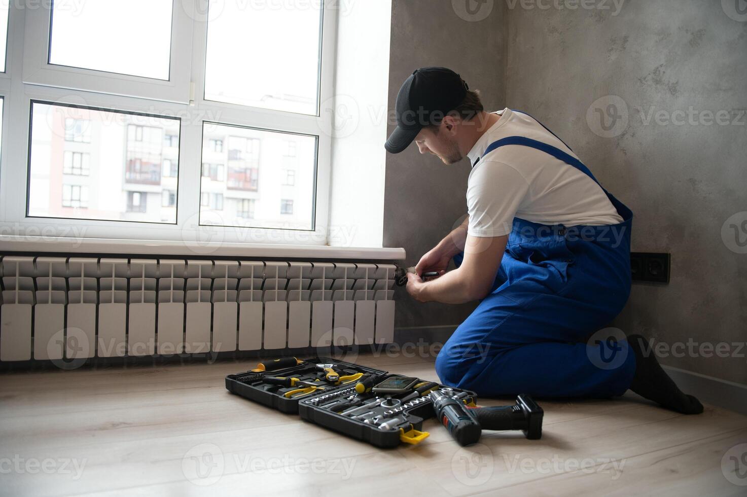 heating system installation and maintenance service. plumber installing radiator. photo