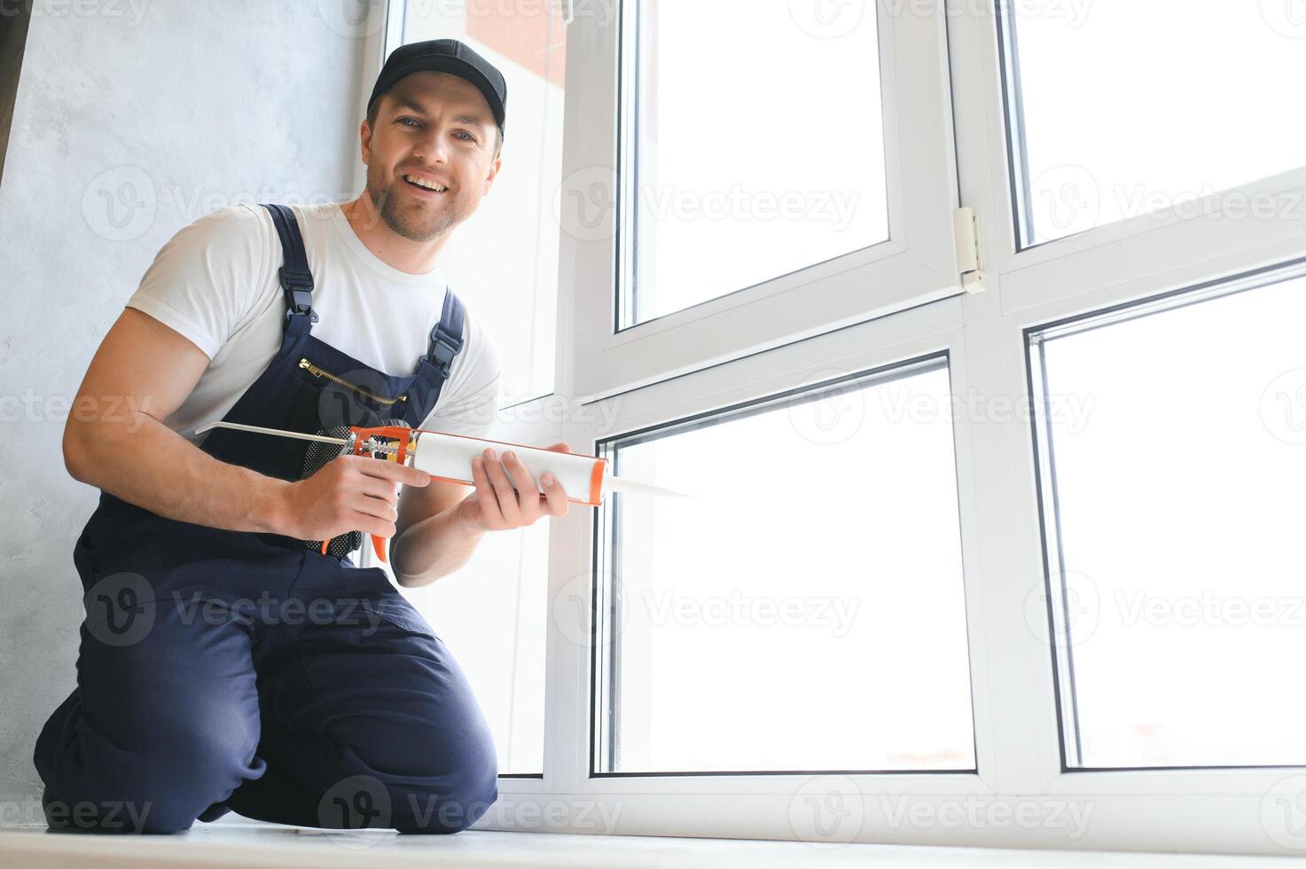 Construction worker installing window in house photo