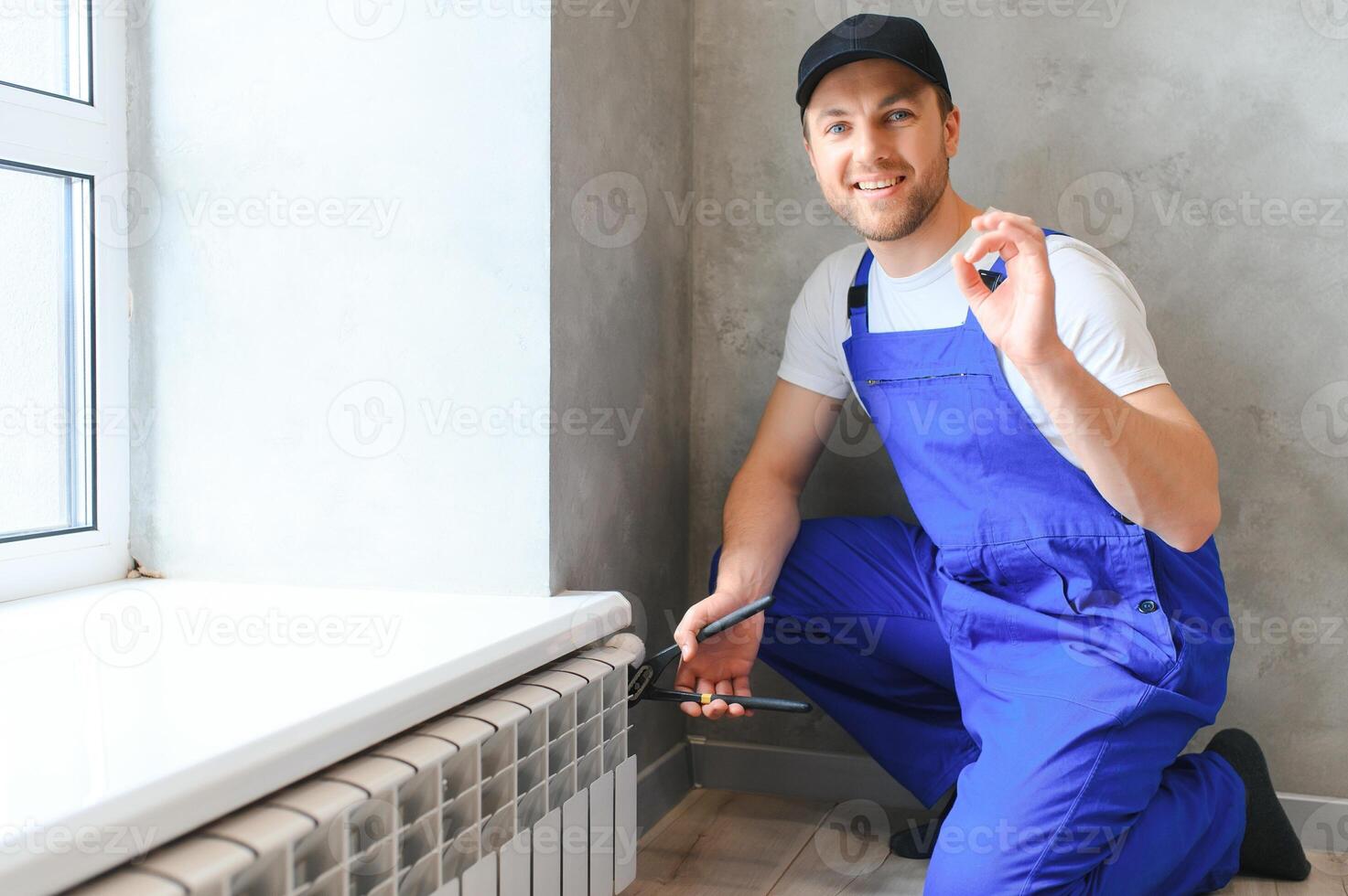 heating system installation and maintenance service. plumber installing radiator. photo