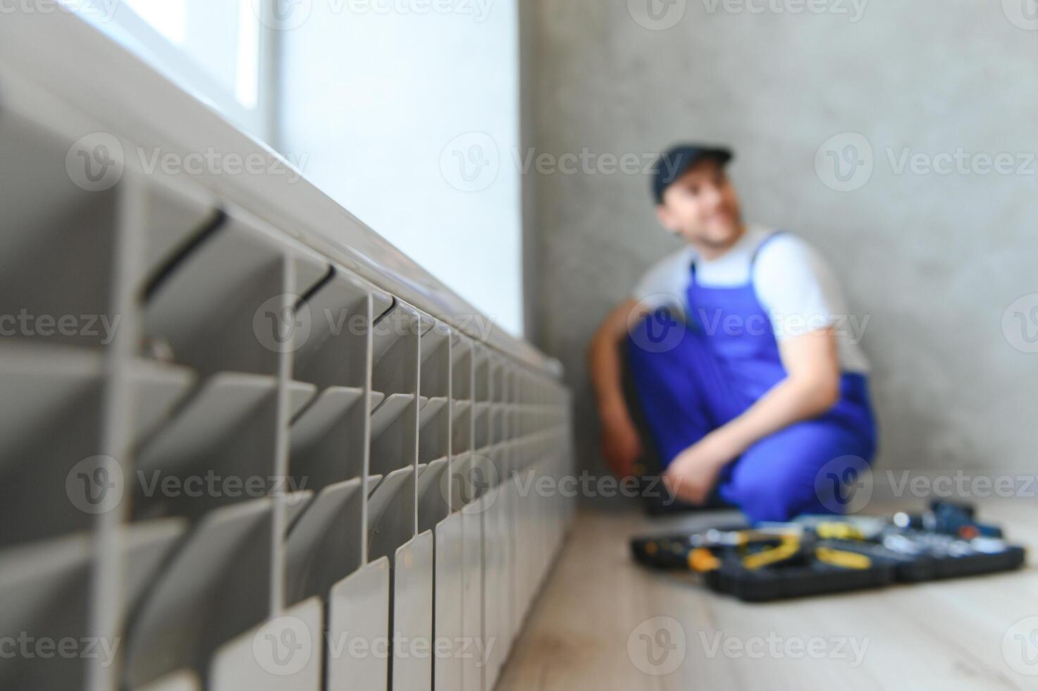 heating system installation and maintenance service. plumber installing radiator. photo