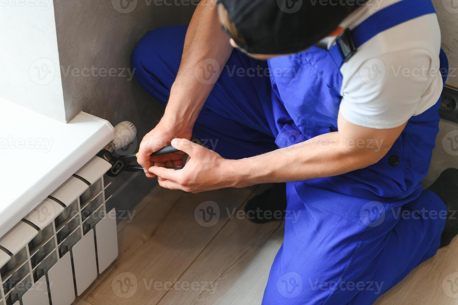heating system installation and maintenance service. plumber installing radiator. photo