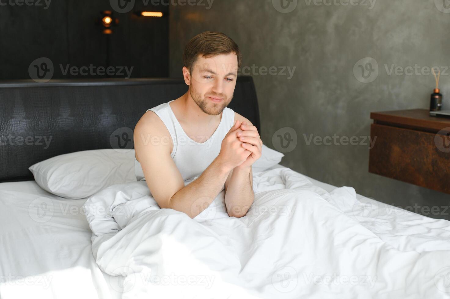 Cheerful Man Waking Up Lying In Cozy Bed At Home On Weekend Morning. Healthy Sleep Concept photo