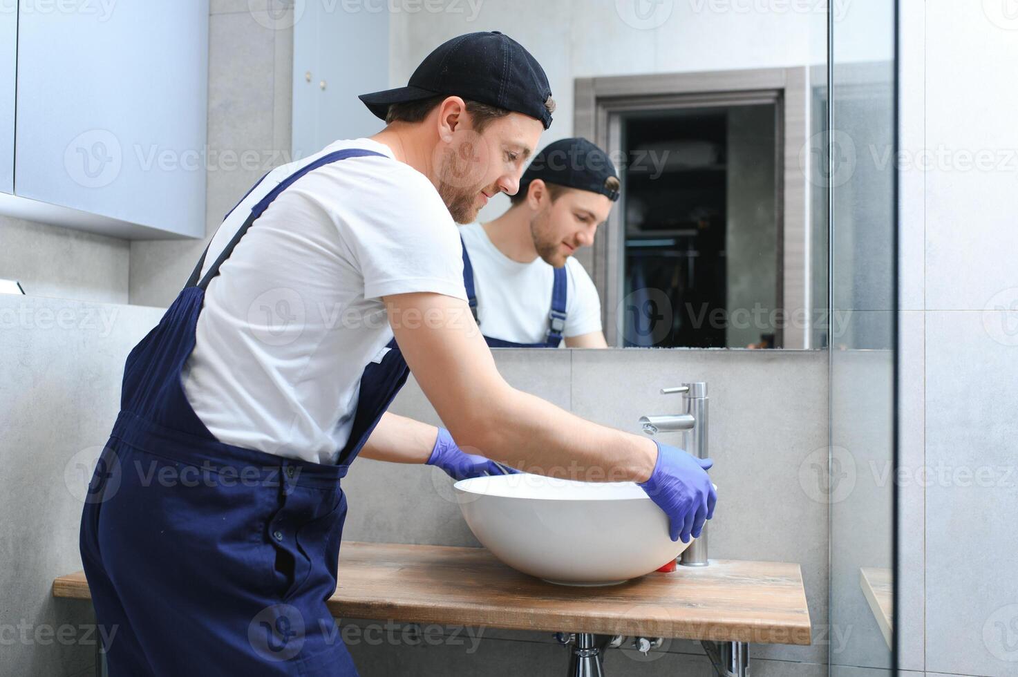 Young Handyman Installing Sink In Bathroom photo