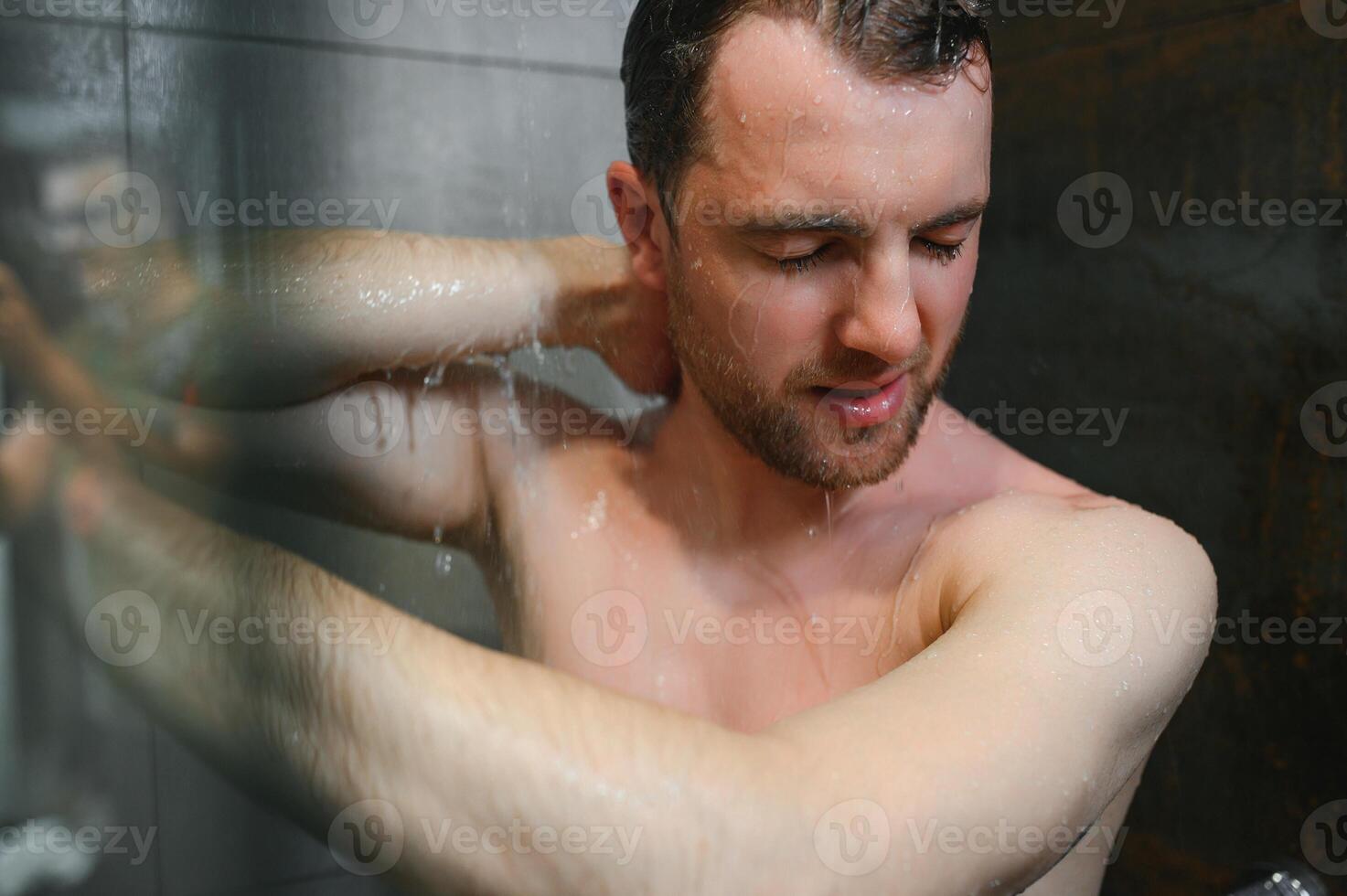 relaxing time.fresh shower concept.under good looking man is under water drops photo