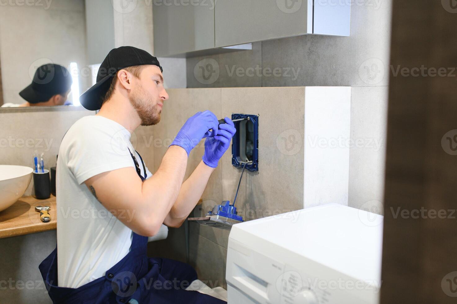 Plumber installing toilet bowl in restroom, work in bathroom. photo