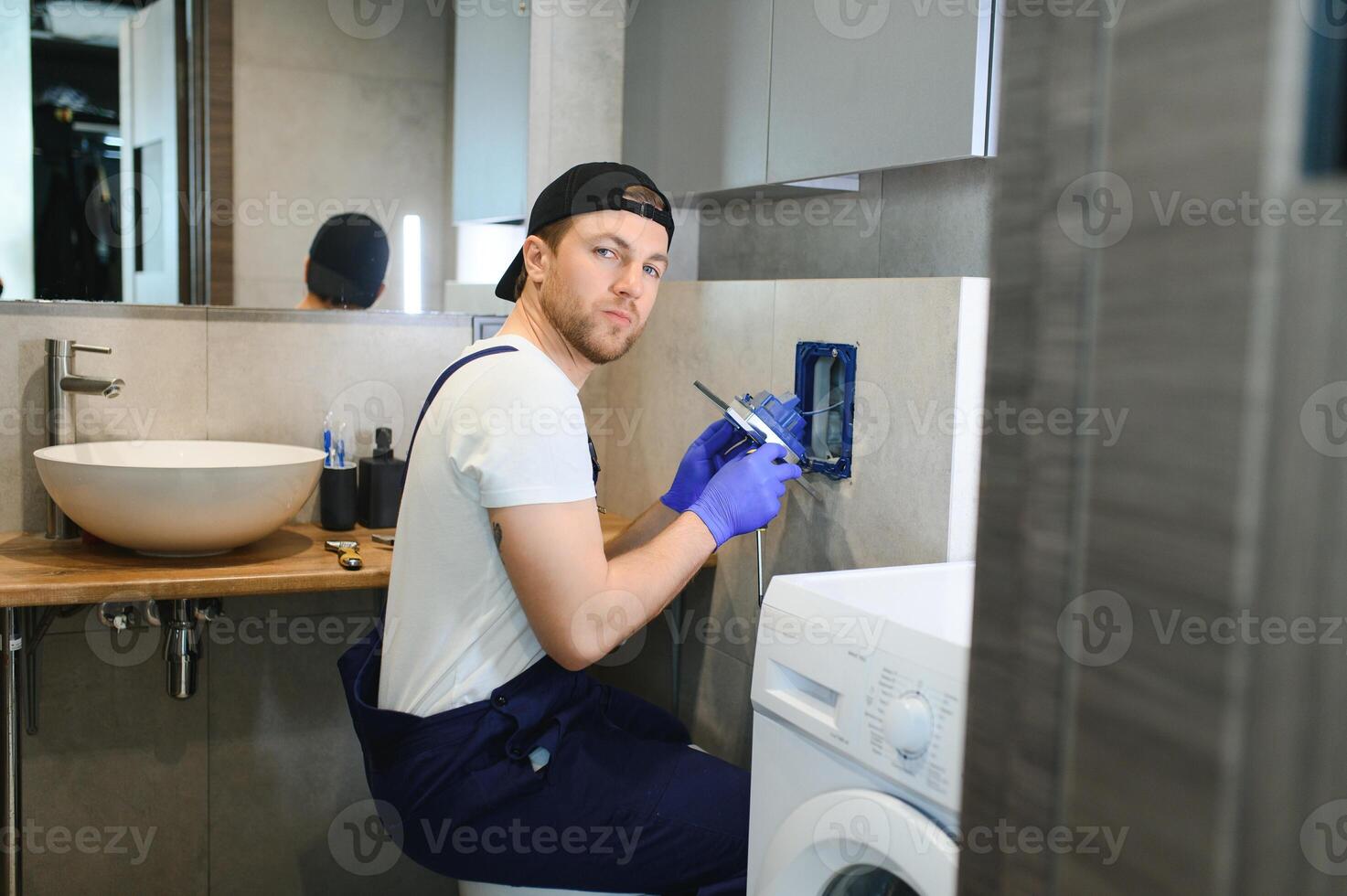 Plumber installing toilet bowl in restroom, work in bathroom. photo
