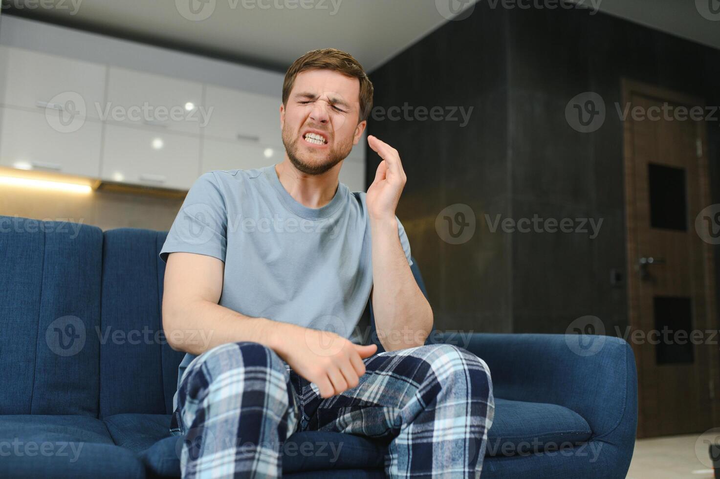 Morning of young man suffering from hangover at home photo