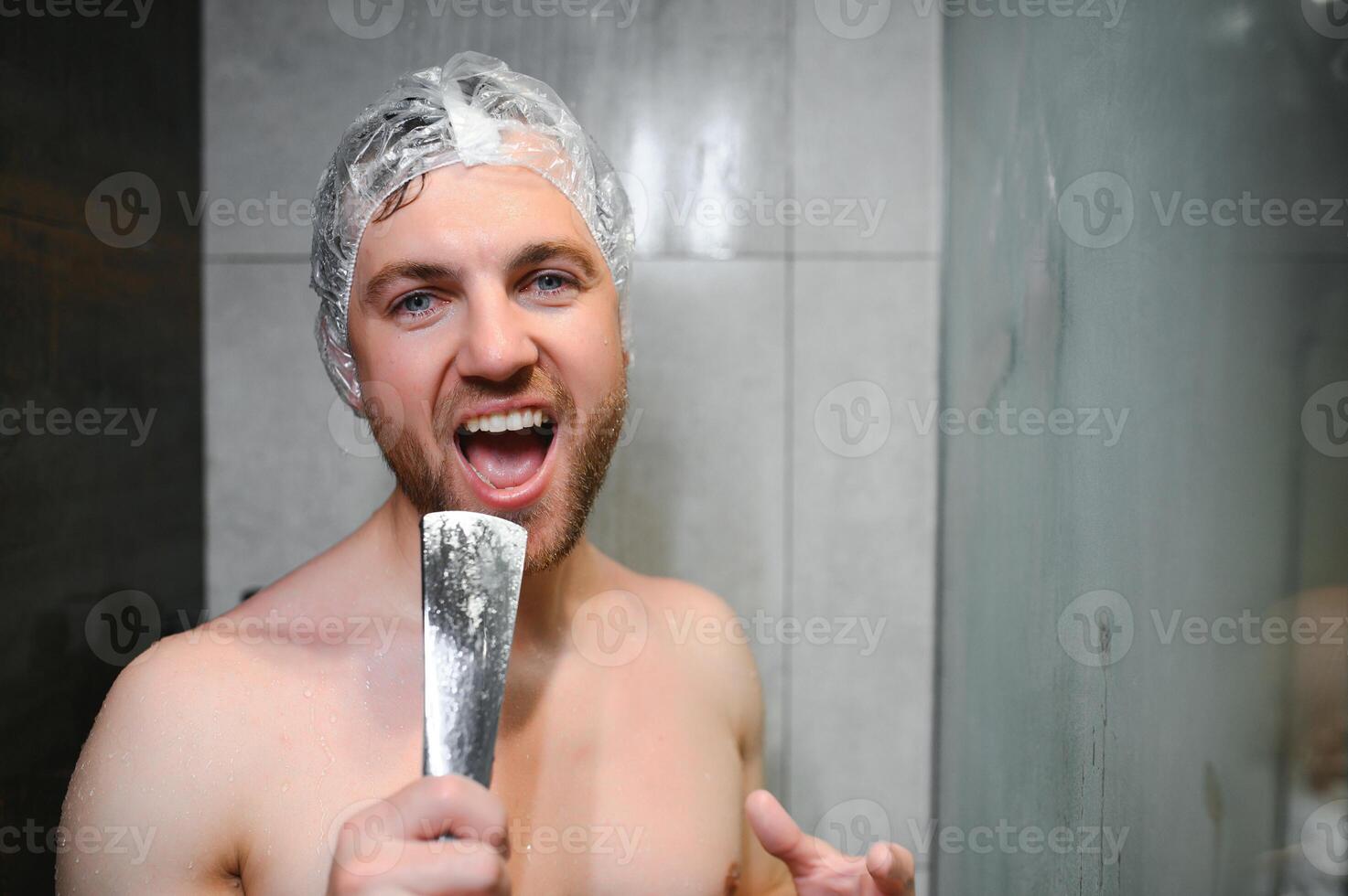 Handsome man singing while taking shower at home photo
