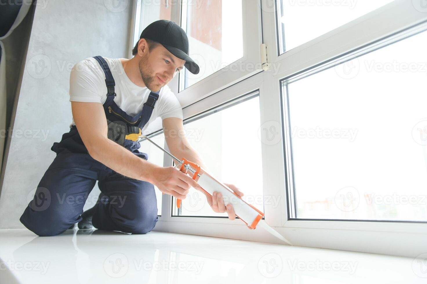 Construction worker installing window in house photo