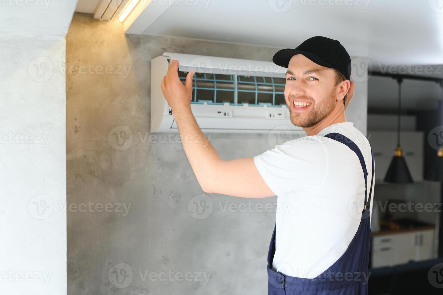 Portrait Of A Young Man Adjusting Air Conditioning System photo