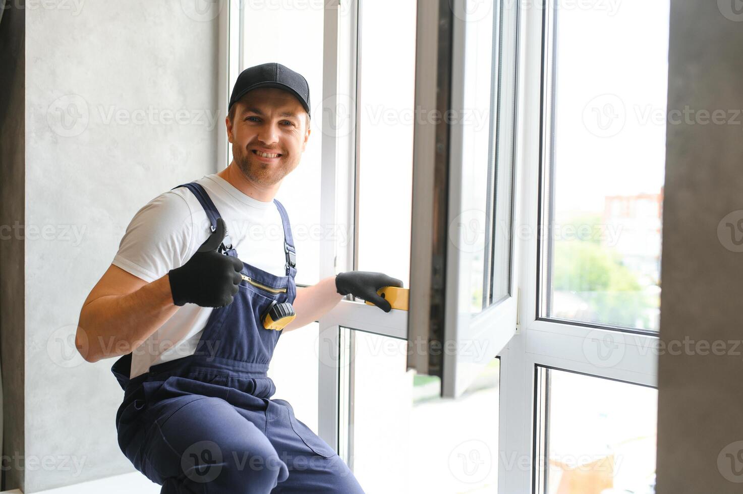 The foreman installs a window frame in the room photo